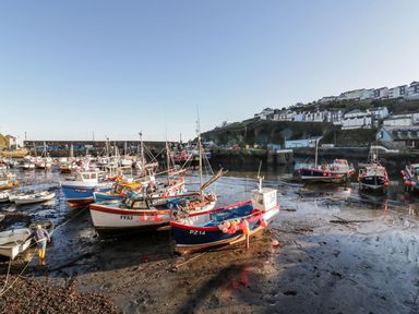 Boats anchored in a harbor with houses on a hillside at Sebright in St Austell