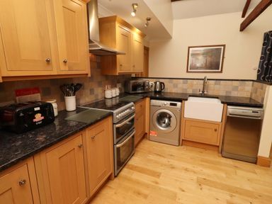 A kitchen with cabinets and appliances at Stable D'or in Embleton