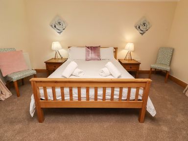 A bedroom with a bed and nightstands at Stable D'or in Embleton