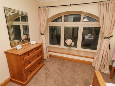 A bedroom with a dresser and a window at Stable D'or in Embleton