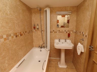 A bathroom with bathtub, sink, and shower at Stable D'or in Embleton