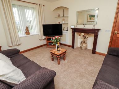 A living room with a television and a table at The Retreat in Embleton