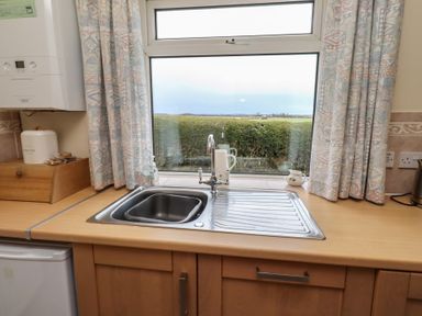 A kitchen with a sink and window at The Retreat in Embleton