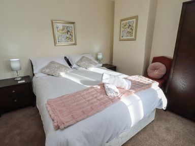 A bedroom with a bed and nightstands at The Retreat in Embleton