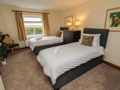 A bedroom with two single beds and a window at The Retreat in Embleton