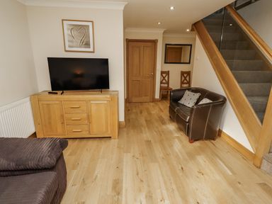 A living room featuring a television and a sideboard at Low Croft in Embleton