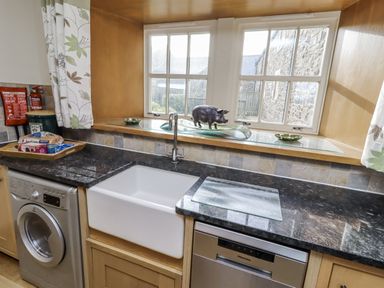 A kitchen with a sink and washing machine at Low Croft in Embleton