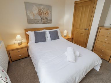 A bedroom with a bed and bedside tables at Low Croft Embleton