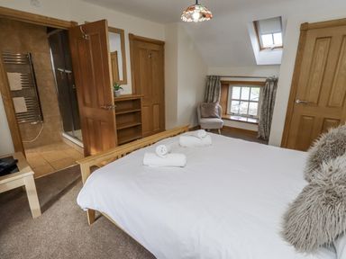 A bedroom with a bed and towels at Low Croft in Embleton