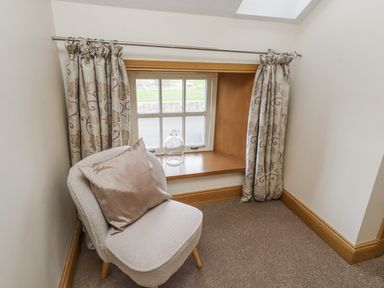 A snug with a chair and window at Low Croft in Embleton