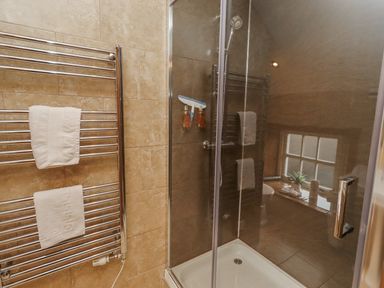 A bathroom with a shower and towel rack at Low Croft in Embleton