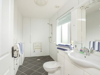 A bathroom with a toilet sink shower and striped towels at Red Ridge in Llandanwg near Harlech