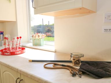 A kitchen counter with a window showing a flower arrangement and a tray with glasses at Downs View in Norton Ferris