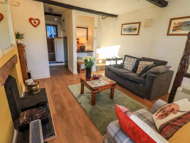 A living room with a sofa and coffee table at Buttonhole Cottage in Ambleside