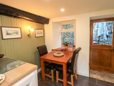 A kitchen with a table and chairs at Buttonhole Cottage in Ambleside
