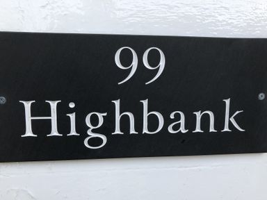 A house number plaque showing 99 Highbank at Highbank in Bowness