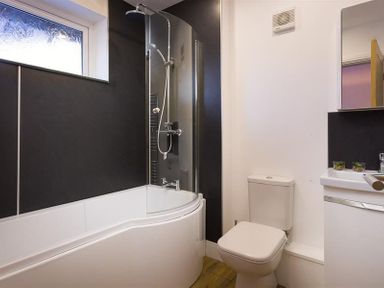 A bathroom with a bathtub shower combination toilet and sink at Lanterns At Grasmere in Grasmere