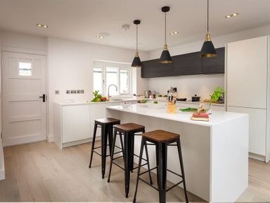 A kitchen with a white island and three bar stools at Underhowe in Grasmere