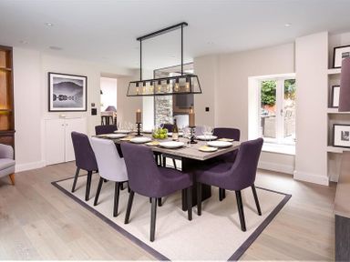 A dining room with a table set for six and purple chairs at Underhowe in Grasmere