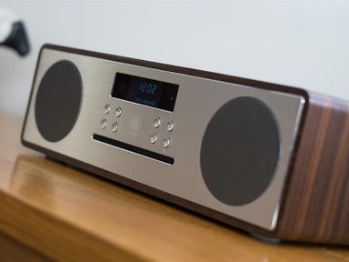 A close up of a wooden radio with speakers and buttons on a wooden surface at Hill Cottage in Ambleside
