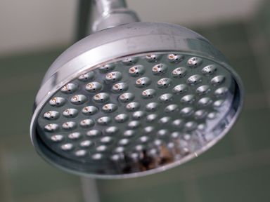 A close up of a chrome showerhead in a bathroom at Hill Cottage in Ambleside