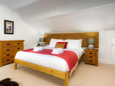 A bedroom with a double bed and wooden furniture at Ellerthwaite House in Windermere