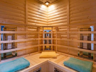A wooden sauna interior with three towels placed on the benches at Heathfield in Keswick
