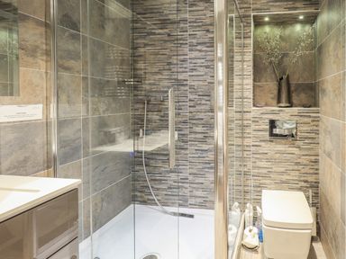 A bathroom with a glass shower enclosure a toilet and a sink at Pure Grace in Ambleside