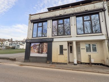 A building with large windows and a sign for Lakelovers Gold Luxury Cottage Collection at Windows in Ambleside