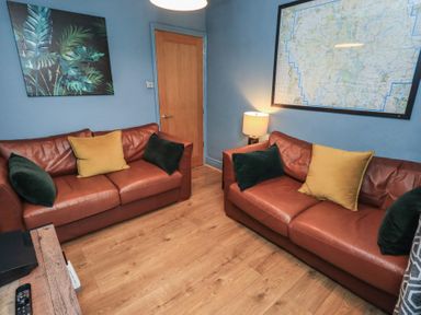 A living room with two sofas and a lamp at Newby Bridge House, Newby Bridge
