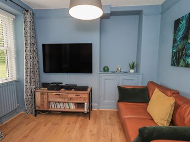 A living room with a television and sofa at Newby Bridge House in Newby Bridge