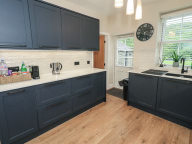 A kitchen with cabinets and appliances at Newby Bridge House in Newby Bridge