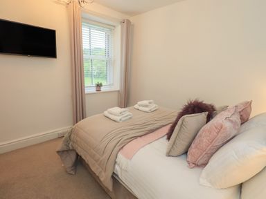 A bedroom with a bed and television at Newby Bridge House in Newby Bridge