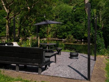An outdoor seating area with a bench and a table at Newby Bridge House in Newby Bridge