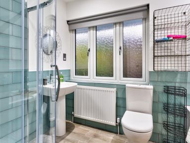 A bathroom with a shower enclosure sink toilet and towel racks at Wynford in Ambleside