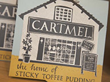 A box with an illustration of a building labeled cartmel and text the home of sticky toffee pudding