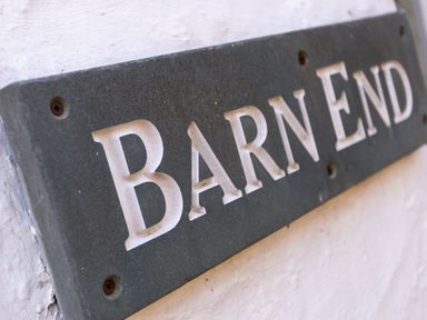 Close up of a sign with the text Barn End mounted on a white wall at Barn End Ambleside