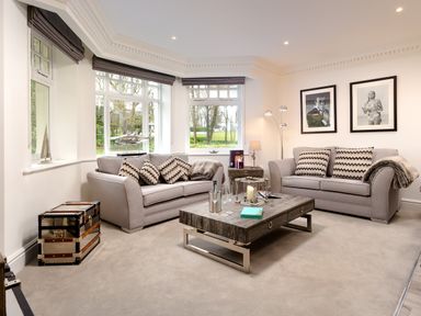 A living room with two sofas a coffee table and framed pictures on the wall at Skyfall in Bowness