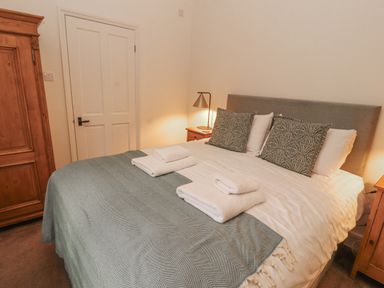 A bedroom with a bed and wardrobe at Rowan Cottage in Grasmere