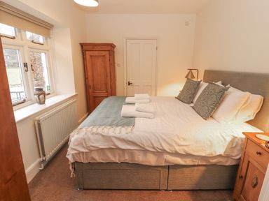 A bedroom with a double bed and a wardrobe at Rowan Cottage in Grasmere