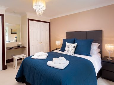 A bedroom with a bed covered in blue bedding and white towels on top at Beech View in Ambleside