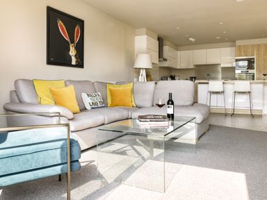 A living room with a sofa and glass coffee table at Take Five in Ambleside