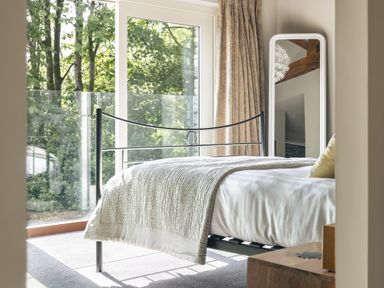 A bedroom with a bed and a mirror at Take Five in Ambleside