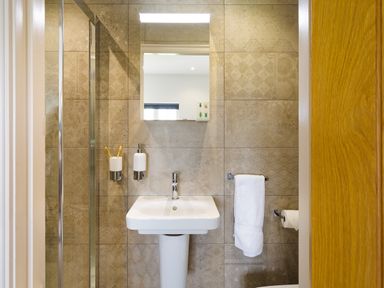 A bathroom with a white pedestal sink mirror and towel on the wall at Hawkrigg Farm in Hawkshead
