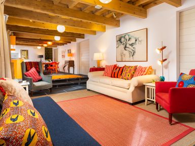 A living room with colorful cushions on sofas and exposed wooden beams at Kentmere Hall Bank Barn in Kentmere