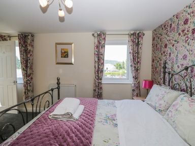 A bedroom with a bed and a window at Woodside West in Bowness