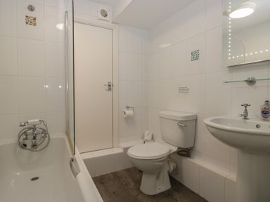 A bathroom with a bathtub, toilet, and sink at Woodside West Bowness