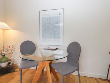 A dining room with a round table and two chairs at Corner Cottage in Troutbeck