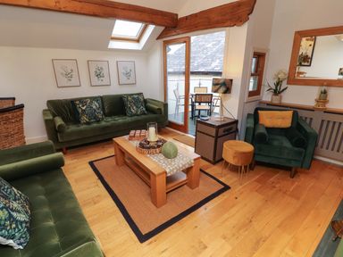 A living room with sofas and a coffee table at Workshop Cottage in Bowness