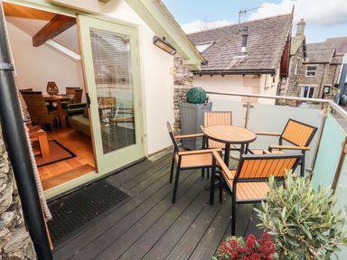 A balcony with a table and chairs at Workshop Cottage in Bowness